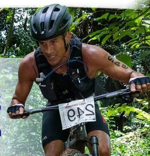 Coureur VTT en pleine course en forêt, partenaire Hydratis